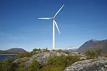 Une éolienne, avec des montagnes en arrière-plan.