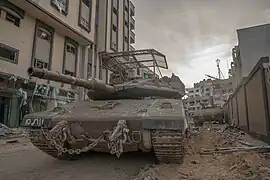 Un Merkava Mk. 4 progressant dans une rue de Gaza, lors de l'opération Swords of Iron, en novembre 2023.