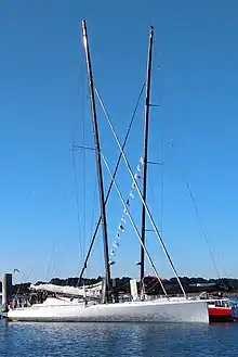 Vu de profil, en entier, bateau blanc amarré au ponton.