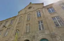  Façade du temple de Plaisance dans le ciel bleu de juin, style néo-roman, pignon surmonté d'une croix