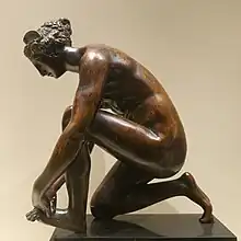 Statuette en bronze représentant une jeune femme agenouillée et tenant son pied gauche