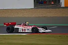 Photo d'une monoplace rouge et blanche en piste.