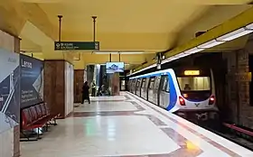 Quai central avec au centre une rangée de gros piliers, le sol et les piliers sont en marbre rouge et blanc avec des motifs géométriques