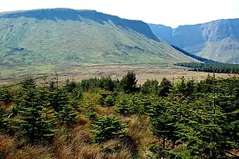 Photographie de falaises dominant un paysage de landes.