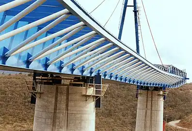 Lancement de la charpente métallique avec un avant-bec et un mât de haubanage provisoire.