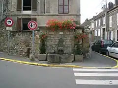 Fontaine, à l'angle nord de la rue de la Gare et de la rue du Montcel.