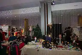 Des personnes assises devant des stands d'objet de Noel