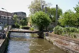 Vue d'un bâtiment d'une ancienne usine sur les bords d'une rivière.