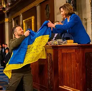 Volodymyr Zelensky lors du discours au Congrès américain, le 22 décembre 2022, transmettant le drapeau de l'Ukraine des combattants de Bakhmout.