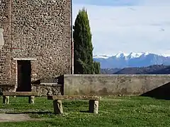 Photographie en couleurs de remparts avec des montagnes enneigées en fond.