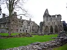 On voit une photo de l'abbaye de Wenlock. À droite le monastère qui est toujours debout. À gauche les ruines de l'ancien abbaye