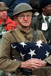 Joseph Ambrose, 86 ans au moment de la photo, vétéran de la Première Guerre mondiale attendant le passage de la parade en 1982. Il tient dans ses bras le drapeau qui couvrait le cercueil de son fils, tué pendant la Guerre de Corée.