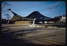 Photographie d’un bâtiment dont le toit à des courbes sinueuses.